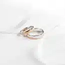 two wedding rings sitting on top of a white cloth