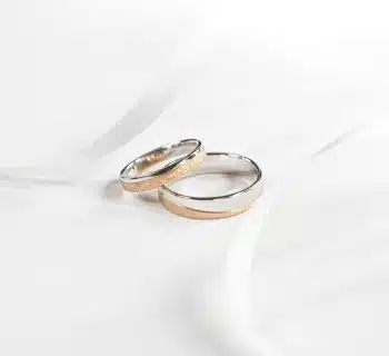 two wedding rings sitting on top of a white cloth