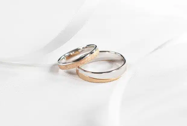 two wedding rings sitting on top of a white cloth