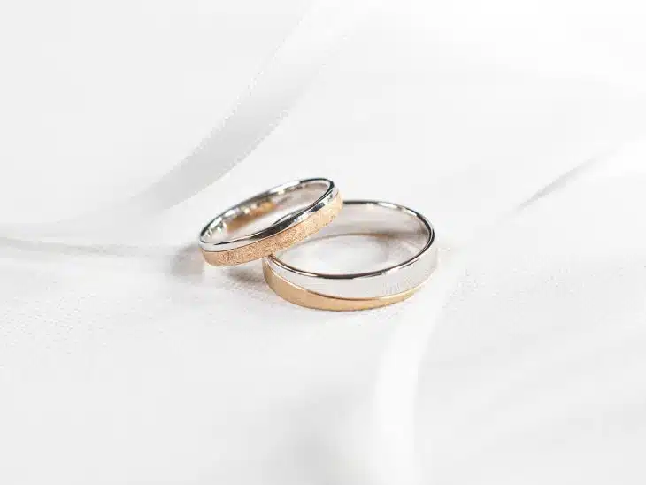two wedding rings sitting on top of a white cloth